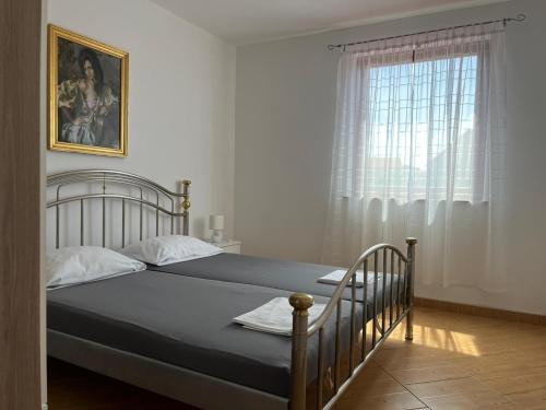 a bedroom with a bed and a window at Apartmani Ana in Sukošan