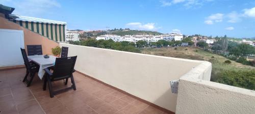 ein Balkon mit Tisch und Stühlen auf einem Gebäude in der Unterkunft Ático - CENTRO de Sabinillas - Calle la Pasionaria - in San Luis de Sabinillas