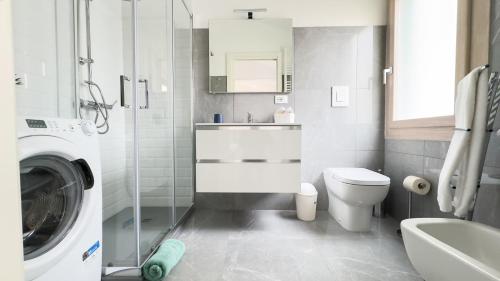 a bathroom with a toilet sink and a washing machine at Orchidea & Ortensia by Ca-Sa Check in Chioggia