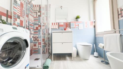 a bathroom with a washing machine and a toilet at Orchidea & Ortensia by Ca-Sa Check in Chioggia