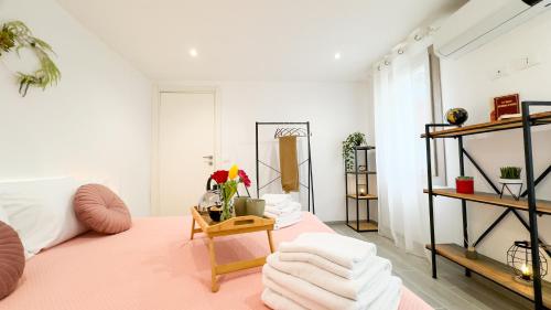 a room with a bed and a table with towels at Orchidea & Ortensia by Ca-Sa Check in Chioggia