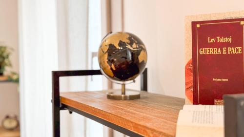 a globe sitting on a table next to a book at Orchidea & Ortensia by Ca-Sa Check in Chioggia