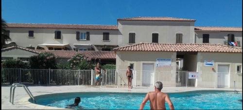 un groupe de personnes dans une piscine dans l'établissement Appartement Avec Jardin et piscine, à Narbonne