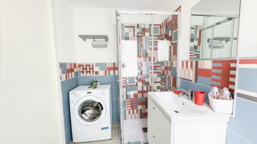 a bathroom with a washing machine and a mirror at Orchidea & Ortensia by Ca-Sa Check in Chioggia