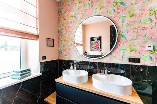 a bathroom with two sinks and a mirror at Villa Magnolia Wissembourg in Wissembourg