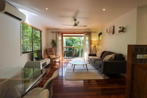 a living room with a couch and a table at Regent Bower Cottage in Eagle Heights