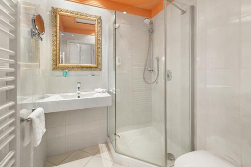 a bathroom with a shower and a sink and a toilet at Hotel Dreiflüssehof in Passau