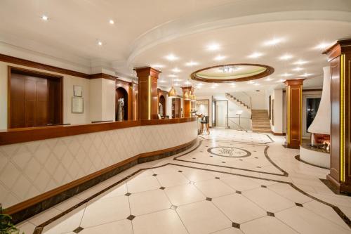 a lobby of a hotel with a staircase at Hotel Dreiflüssehof in Passau