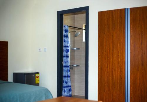 a bedroom with a bed and a shower and a door at Atlantic Bay Resort, Prampram in Prampram