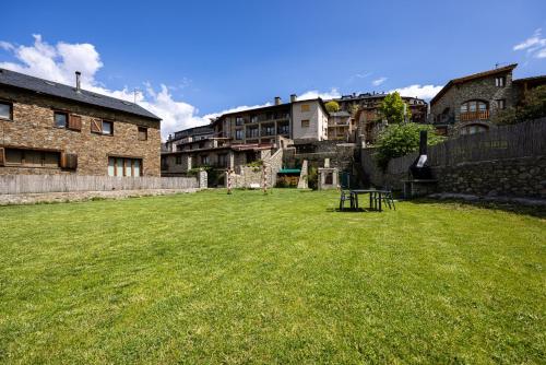 a large grassy yard with buildings in the background at Aparthotel Bellver in Bellver de Cerdanya 