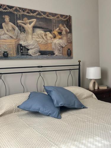 a bedroom with a bed with a painting on the wall at Loano Casa Archè villa indipendente con giardino in Loano