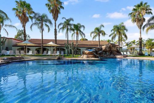a swimming pool with a water slide in front of a house at Quality Resort Siesta in Albury