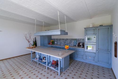 a kitchen with blue cabinets and a counter top at Bed & Breakfast Barbera e Tulipani in Scandeluzza