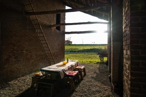 a table in a brick building with a view of a field at Bed & Breakfast Barbera e Tulipani in Scandeluzza