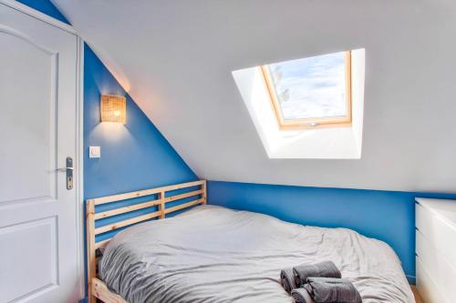 un lit dans une chambre avec un mur bleu dans l'établissement Charming seaside house, à Varaville