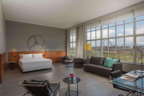 a living room with a bed and a couch at NH Torino Lingotto Congress in Turin