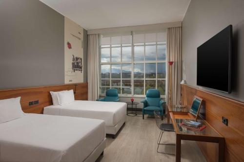 Habitación de hotel con 2 camas y TV de pantalla plana. en NH Torino Lingotto Congress en Turín