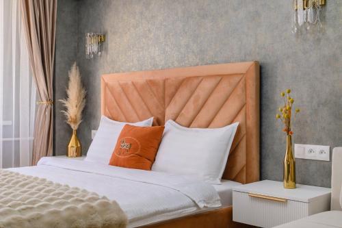 a bedroom with a bed with orange and white pillows at Шелковый Путь Премиум in Almaty