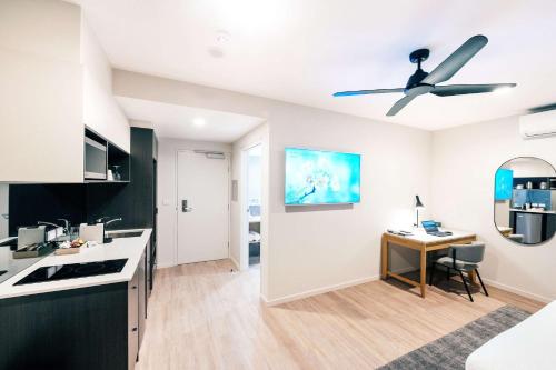 a kitchen with a ceiling fan and a desk at Quality Hotel City Centre in Coffs Harbour