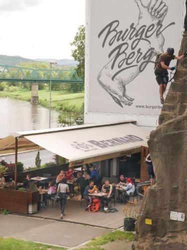 a group of people sitting at tables outside a restaurant at Penzion Via Ferrata in Děčín