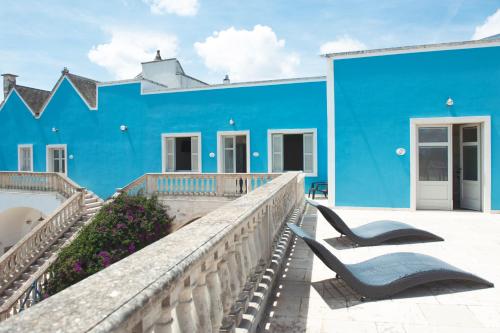 a blue building with a chair in front of it at Agriturismo Masseria Calongo in Cisternino