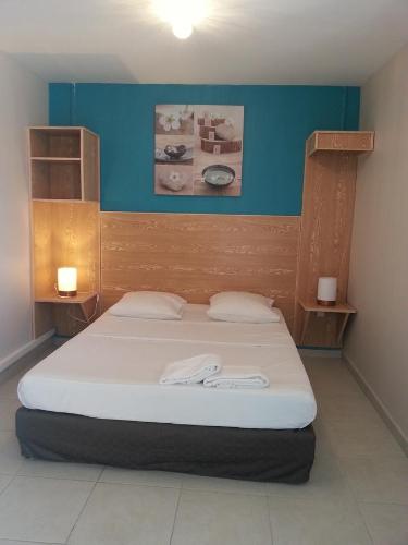 a bedroom with a bed with two towels on it at L'ANNEXE 66 , Saint Denis Centre Ville , à 200 m de la Rue Piétonne , du Petit Marché et du Leader Price , sur une rue calme, PARKING GRATUIT sur la rue in Saint-Denis