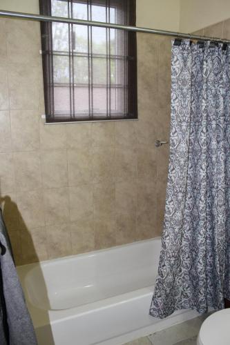 a bathroom with a tub and a shower curtain at Eclipse Suite Guest Apartment in Kingston