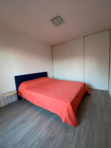 une chambre avec un lit rouge dans une pièce dans l'établissement grand f2 climatisé avec wifi plein centre BORGO, à Borgo