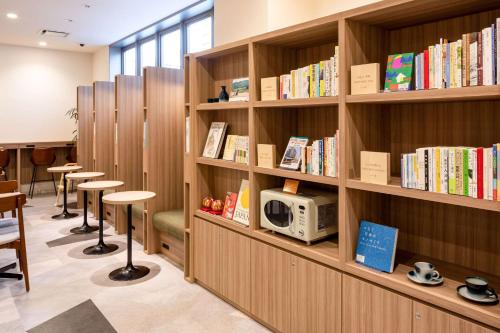 a library with wooden shelves filled with books at Comfort Hotel Matsuyama in Matsuyama