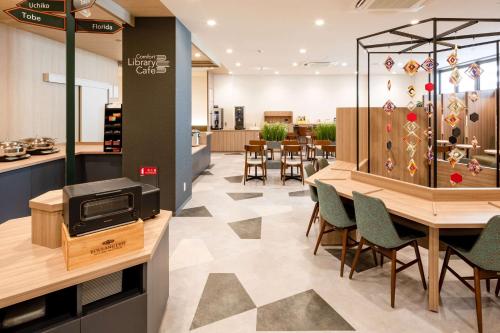 a restaurant with a dining room with tables and chairs at Comfort Hotel Matsuyama in Matsuyama
