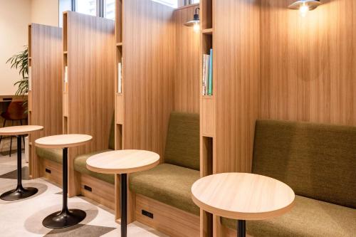a waiting room with two tables and two stools at Comfort Hotel Matsuyama in Matsuyama