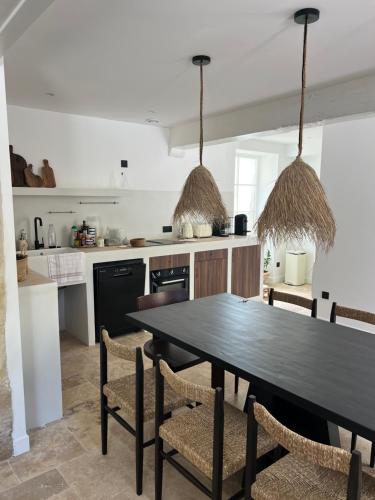 une cuisine avec une table et des chaises noires dans l'établissement Villa Garonne, à Quinsac