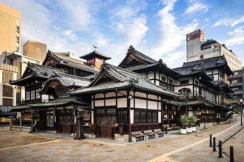 an asian building with a roof on a street at Comfort Hotel Matsuyama in Matsuyama