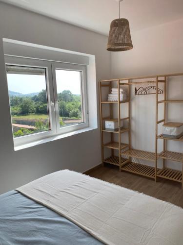 Un dormitorio con una cama y dos ventanas en O Mirador Alere Carnota playa, en San Mamede de Carnota