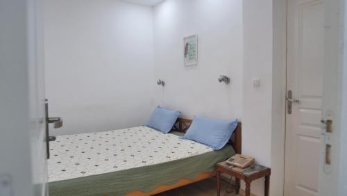 a small bed with blue pillows in a room at Radama Hotel in Antananarivo