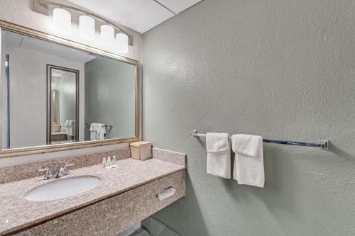 a bathroom with a sink and a mirror and towels at Quality Inn in Dalton