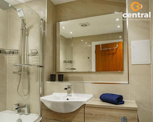 a bathroom with a sink and a shower and a mirror at City Quay by CENTRAL SERVICED APARTMENTS - 2 Bedroom - City Quay Views - Walk Into the City Centre - Smart TVs in All Rooms - We are your Short Term Stay Specialists in Dundee - Get in touch to book your stay - CENTRAL SHORT LETS Dundee in Dundee