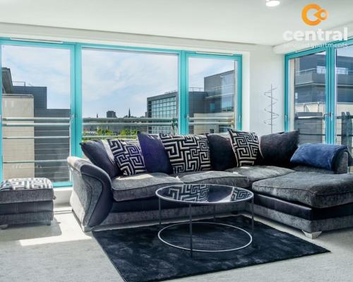 a living room with a couch and a table at City Quay by CENTRAL SERVICED APARTMENTS - 2 Bedrooms - City Quay Views - Walk Into Dundee City Centre - Walk Away From Bus & Train Station - Lift Access in Dundee