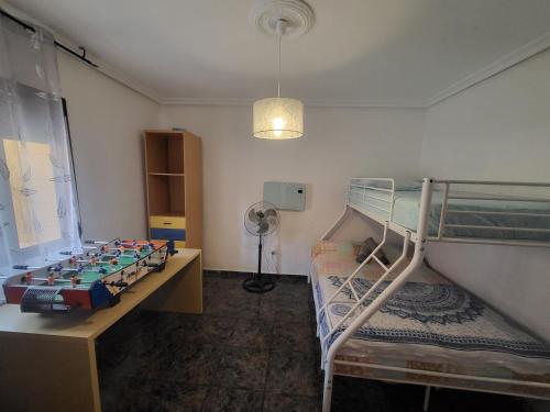 a room with two bunk beds and a desk and a lamp at Casa Oasis Puertollano, una casa rural en Puertollano, agradable, con Piscina en zona tranquila in Puertollano