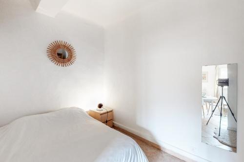 un dormitorio con una cama y un espejo en Le Pǐgeonnier - Un Voyage En Provence, en Aix-en-Provence