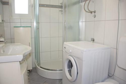 a white bathroom with a washing machine and a shower at Beachside Babe in Novalja
