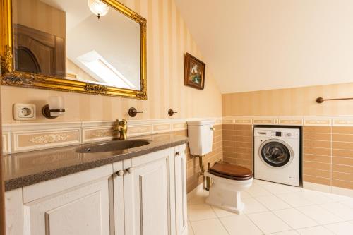 a bathroom with a sink and a washing machine at Sofijos apartamentai in Klaipėda