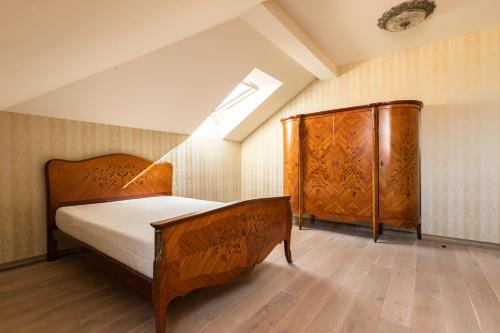 an attic bedroom with a bed and a skylight at Sofijos apartamentai in Klaipėda