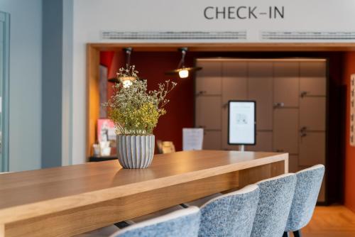 a table with a vase of flowers on top of it at Hotel Oltnerhof - Self Check in in Olten