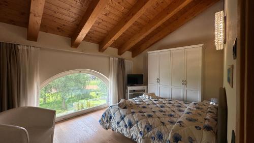 a bedroom with a bed and a large window at Agriturismo Lambra La Casa Del Sol in Asiago