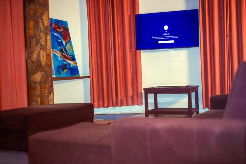 a room with a couch and a table in front of a screen at Atlantic Bay Resort, Prampram in Prampram