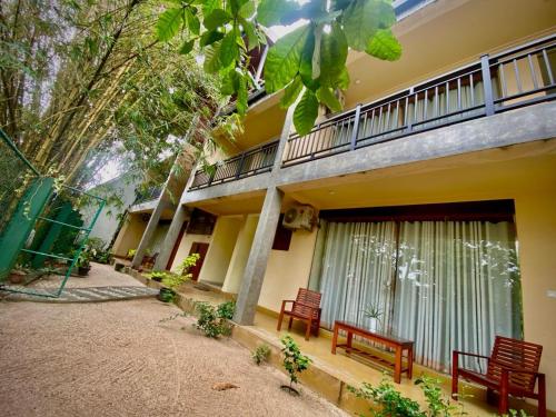 a building with two red benches in front of it at Woodnest Villa Rustic in Kochchikade