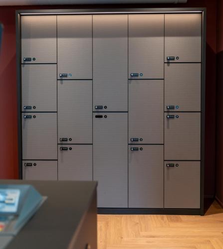 a row of lockers in a room with wood floors at Hotel Oltnerhof - Self Check in in Olten