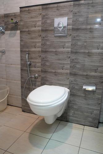 a bathroom with a toilet and a shower stall at North Centre in Cochin