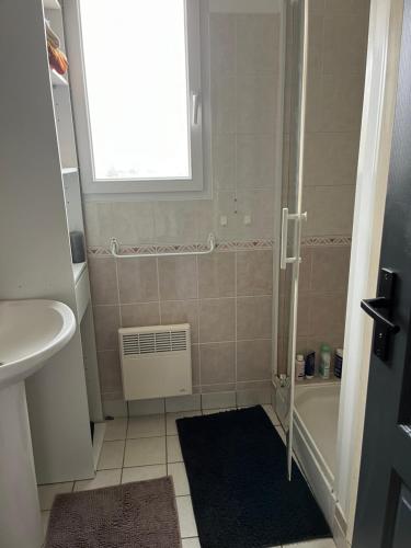 La salle de bains est pourvue d'un lavabo, d'une baignoire et d'une fenêtre. dans l'établissement Jolie maison à 20 min du circuit des 24h, à Soulitré